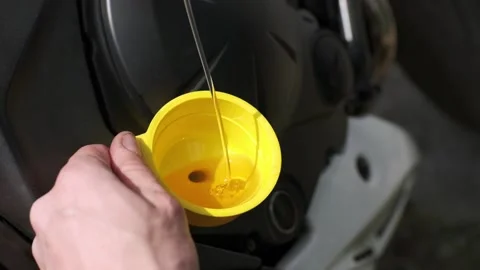 Biker change engine oil on motorcycle. Pouring oil to motorcycle engine. Stock Footage 152181700