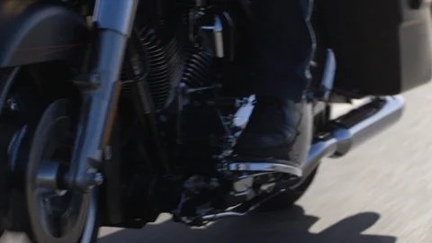 Biker changing the gear of motorcycle while riding on road Stock Footage