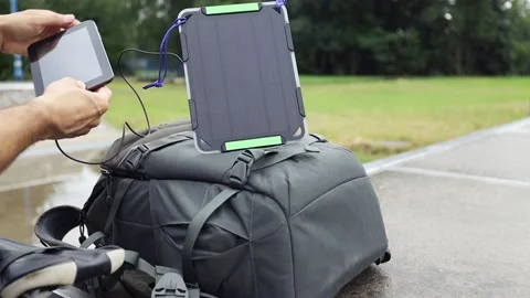 Biker charges tablet using solar panel on his backpack. Stock Footage 157333286
