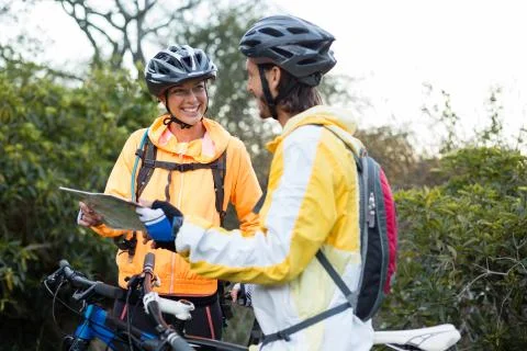 Biker couple interacting over map Fotos Stock