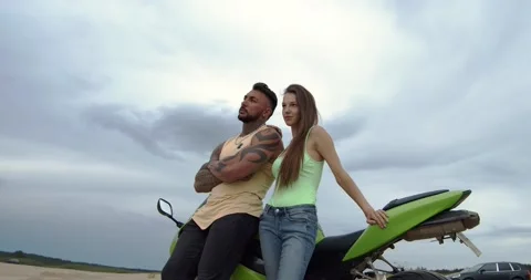 A biker couple leaned on a motorcycle Видео 156555434