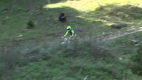 Biker down carefully on a mountain road and through a water stream Stock Footage 82312690