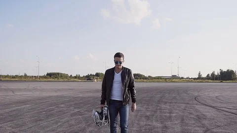 The biker is dressed in leather jacket and jeans, goes to his motorcycle, sits d Stock Footage 81184577