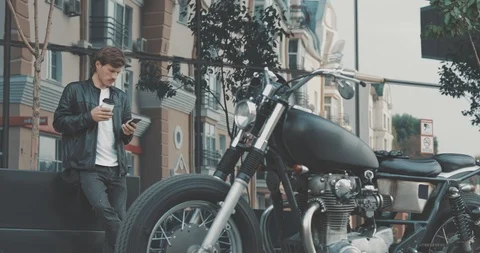 Biker drinking coffee while standing near motorcycle Stock Footage 94595258