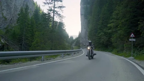 Biker drives motorcycle chopper on empty mountain road road in the morning. 스톡 동영상 150617341