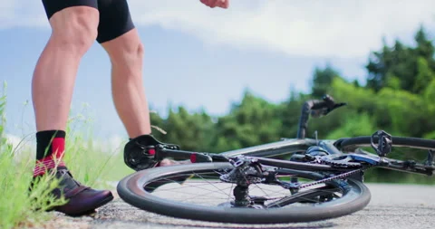 Biker fixes flat tire on road bike during ride in nature on sunny day with Stock Footage 339496066