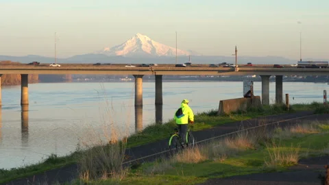 A biker in front of freeway traffic and Mt. Hood, over the Columbia River. Vidéo 143664488