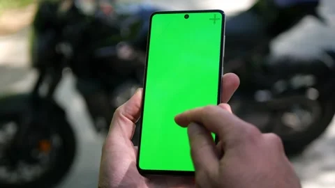Biker hands using his phone with blank green screen chroma key with gestures Stock Footage 156566258