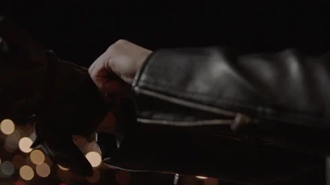 Biker In Leather Jacket, wearing , tying motorcycle black gloves and helmet Stock Footage 219853041