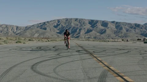 Biker pedaling towards the camera as it moves backwards 1 Stock Footage 106464423