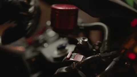 The biker puts his hand on the gas handle on the sport motorcycle and turns on Vidéo 219853107