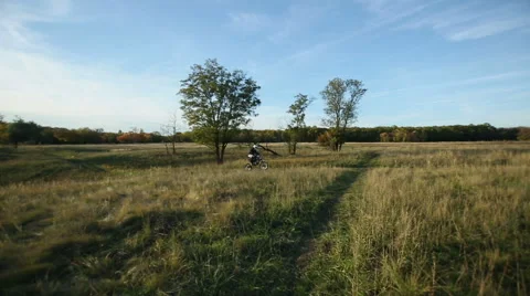 Biker Riding Through a Meadow Stock Footage 40448145