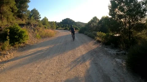 Biker riding through path way amidst mountains and a beautiful landscape Vídeos de archivo 139814058