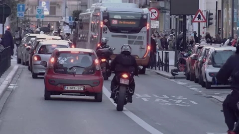 Biker squeezing through traffic and doing a wheele Stock Footage 234339751