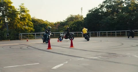 Biker students, together with their instructor in a yellow T-shirt, ride around Stock Footage 249235395