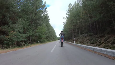 Biker stunt ride biike on mountain rural road and do wheelie on motorcycle Stock-Footage 159560153