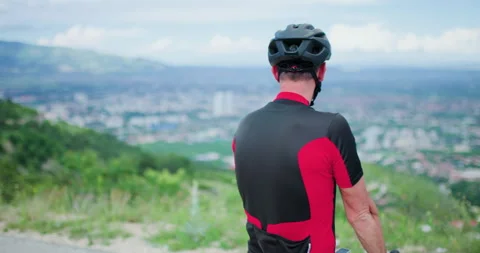 Biker takes a break to enjoy the view from the mountain road before continuing Stock Footage 339495589