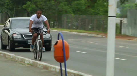 Biker without helmet rides in front o a Mercedes (PoAbikes23) Stock Footage 23732405