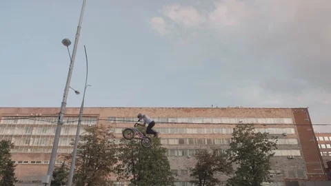 Bikers on BMX cycles do backflips and tailwhips while jumping.Slow motion view 스톡 동영상 121036919
