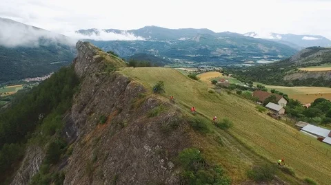 Bikers ride mountain bicycles bikes on cliff edge, epic nature, downhill biking. Stock Footage 125738287