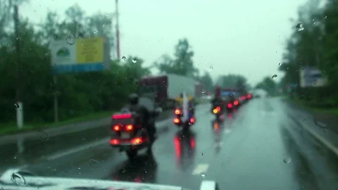 Bikers ride in the rain on the way Stock Footage