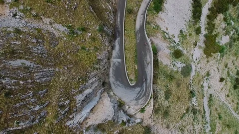 Bikers ride road mountain bikes on serpentine highway. Tour de France route. Stock Footage 126168669