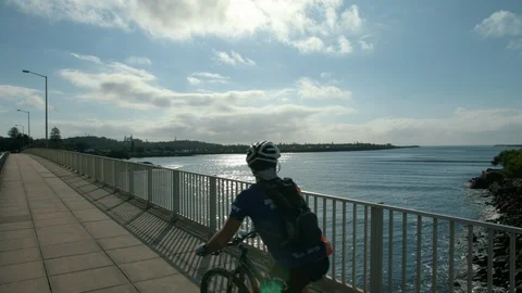 Bikes going over bridge looking out at water Stock Footage 86424080