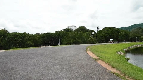 Biking around lake towards camera Stock Footage 65302306