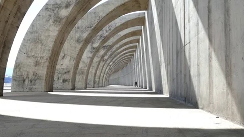Biking bent forward concrete arches Stock Footage 69902486