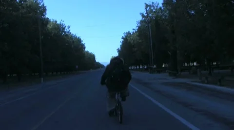 Biking Down the Road Jib Stock Footage 8692396