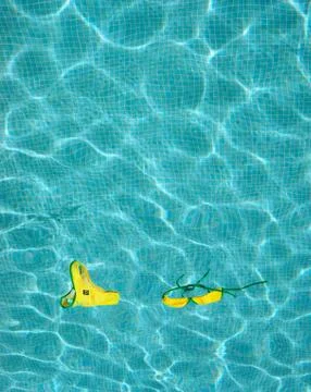 Bikini floating in empty pool Foto stock
