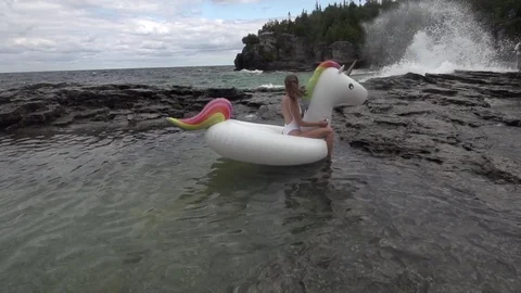 Bikini Girl On Unicorn Pool Floaty Product in Rock Pool Stock Footage 80072270