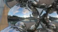 Bilbao city landscape visible in reflective spheres outside Guggenheim Museum HD Footage