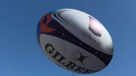 BILBAO, SPAIN; MAY 11 2018: Inflatable rugby ball floating in the clear blue sky 스톡 동영상 335467437