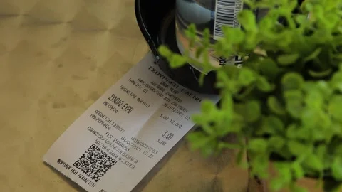 A bill for the dinner laying on the table with green table plant. Stock Footage 199601919
