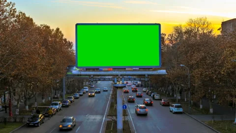 A billboard with green chroma key on the background of fast moving cars at Stock Footage 87566749