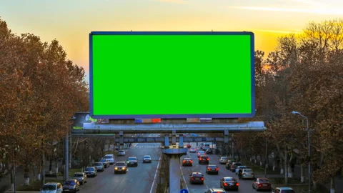 A billboard with green chroma key on the background of fast moving cars Stock Footage 87567242