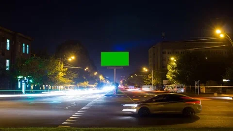 A billboard with a green screen on a background of city traffic with long Stock Footage 83521063