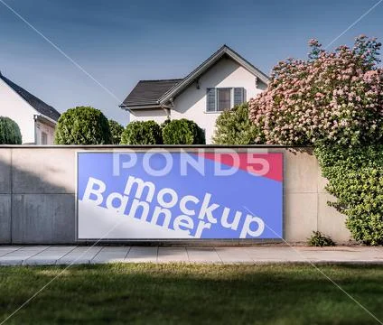 Billboard mockup on wall, houses in the background PSD Template