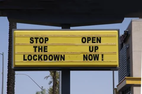 Billboard saying Stop the Lockdown - Open Up Now! Anti-lockdown protests. Stock Photos
