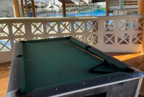 Billiard balls arranged in a triangle and a cue stick are lying on a green .. Stock Photos