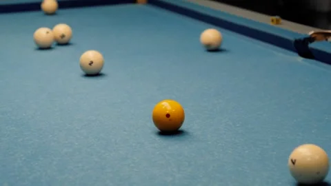 Billiard balls on blue pool table with cue stick close-up Stock Footage 318076091