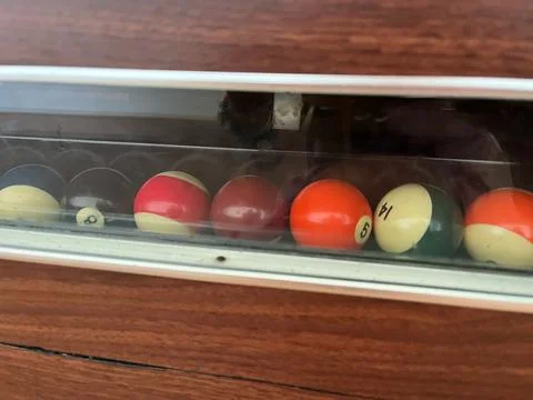 Billiard balls in a plastic box on a wooden table close up Stock Photos