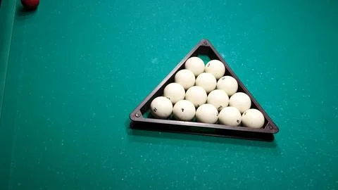 Billiard balls in a triangle on a green pool table. Preparing the pyramid for Stock Photos
