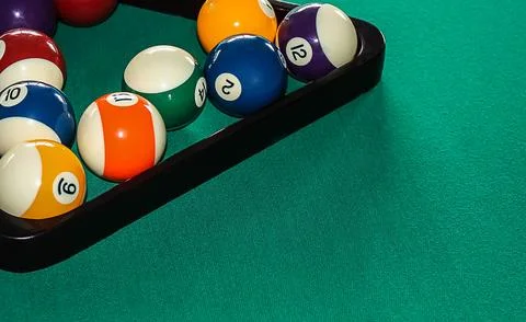 Billiard balls in a triangular rack in the corner of the table with space f.. Stock Photos