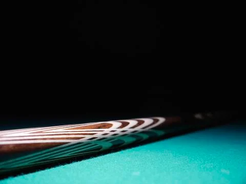 Billiard cue on a table. Close-up. Black background Stock Photos