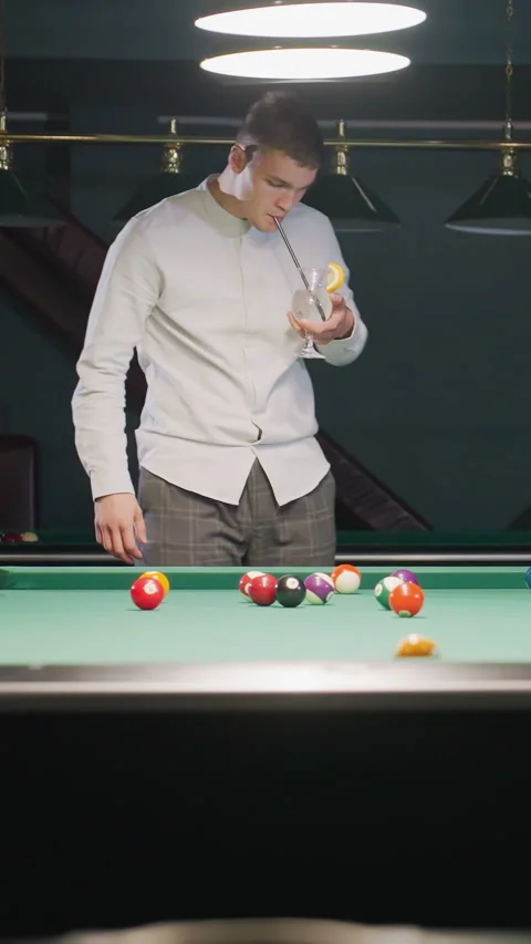 Billiard Player Holding Cue Stick and Lemon Drink While Rolling Ball on Table Stock Footage 319807778