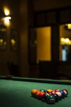 Billiards balls on pool table in cozy dark bar interior Stock Photos