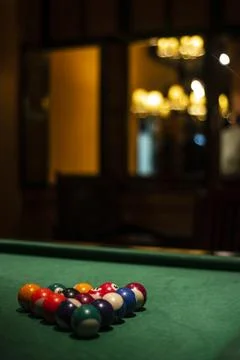 Billiards balls on pool table in cozy dark bar interior Stock Photos