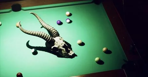 Billiards table with unique skull decor and colorful balls in dim light Stock Illustration